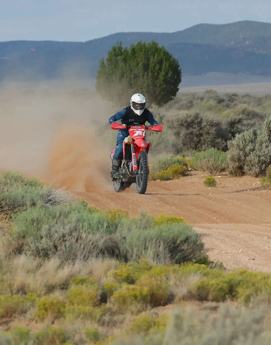 Justin Wallis racing a red Honda down a dusty desert two-track